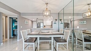 A modern kitchen with white cabinets, a stainless steel refrigerator, and a built-in oven.