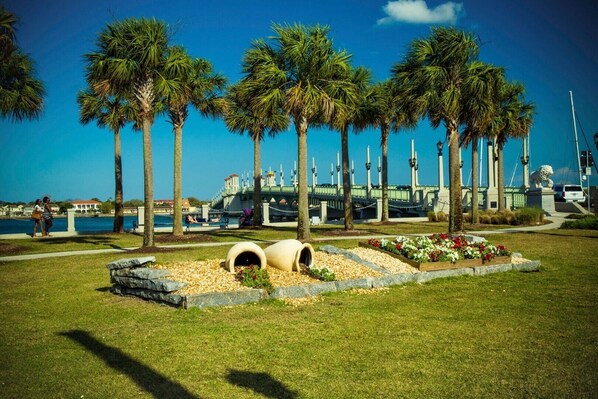 Stroll along the waterfront promenade surrounded by tall palm trees and enjoy the scenic views.