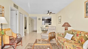 A living room with a sofa, chairs, a coffee table, and a dining area with a table and chairs.