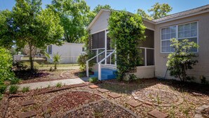 A residential property with a covered porch, a fenced yard, and mature trees. - Seabird Shack: Dog Friendly, Downtown Pensacola! (Pensacola)