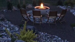 A fire pit with four chairs in a gravel area with a view of a lake and mountains. - Grand Vineyard Estate Home Exceptional Place Best Location in Penticton (Penticton)