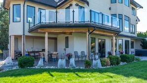 A modern two-story house with a covered patio, outdoor seating, and a well-maintained garden. - Grand Vineyard Estate Home Exceptional Place Best Location in Penticton (Penticton)