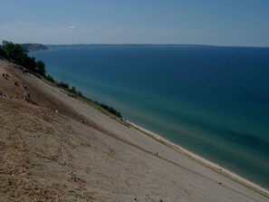 A coastal landscape with a sandy beach and a clear view of the sea.
