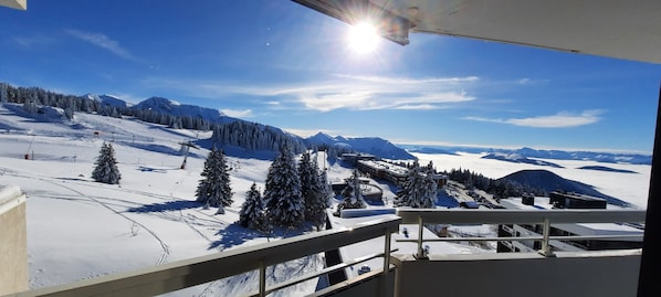 A snowy mountain landscape with a ski resort, including ski lifts and snow-covered trees.