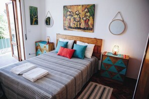 A bedroom with a bed, pillows, a bedside table with a lamp, and artwork on the wall. - Vintage Beach and Golf Villa (Costa da Caparica)
