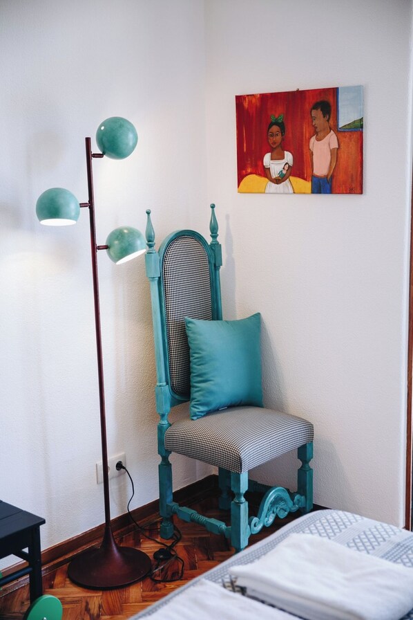 A room with a teal chair, a floor lamp, a painting, and a bed. - Vintage Beach and Golf Villa (Costa da Caparica)