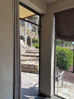 A room with a sliding glass door leading to a stone staircase and outdoor seating area.