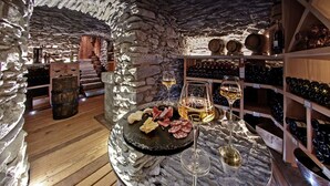 Ein Keller mit Steinwänden, Holzdielen und Weinkisten.