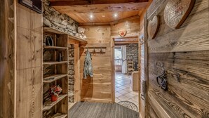 Ein Holzinnenraum mit Steinwand, Holzböden und einem Garderobenhaken.