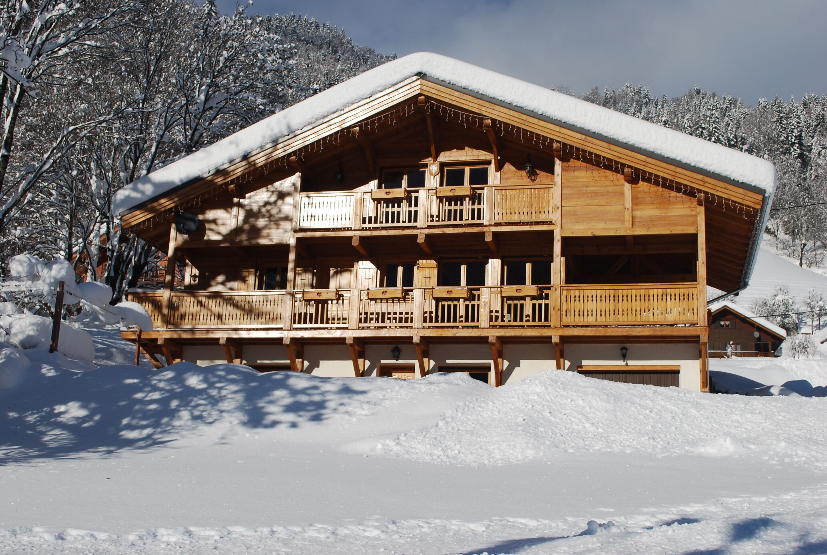 Una cabaña de madera con balcón, rodeada de nieve.