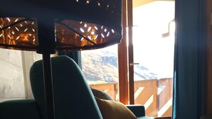 Una habitación con un sofá, un vaso de leche, un libro y una lámpara.