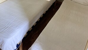 A single bed with a headboard labeled "Dream" and a window with a view of trees.