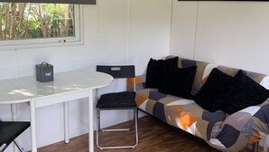 A modern living space with a white table, black chair, and a patterned sofa.
