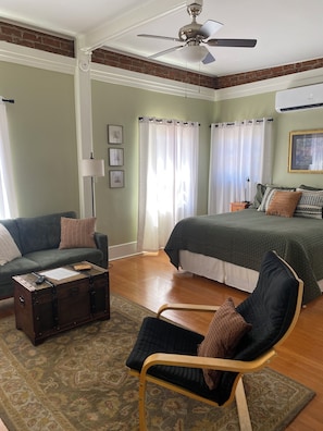A bedroom with a bed, a chair, a couch, a chest of drawers, and a ceiling fan. - Unique , Vintage Studio Apartment for Leisure/Corporate Travel (Tucson)