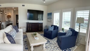 A living room with a sofa, two armchairs, a coffee table, and a TV. - Sweeping Vue of the Gulf of Mexico, 30 steps to beach (Mexico Beach)