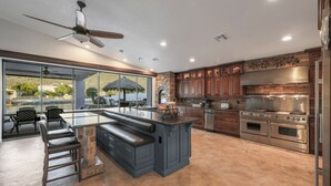 Una cocina amplia con una isla grande, electrodomésticos integrados y vistas al exterior.