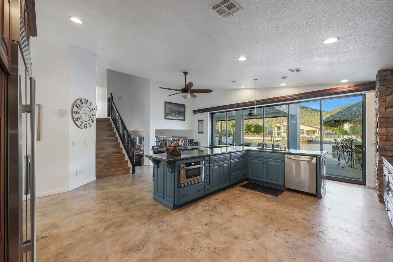 A spacious kitchen with a large island, a built-in oven, and a dishwasher.