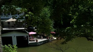 A wooden staircase leading to a dock with two kayaks and a rowboat.