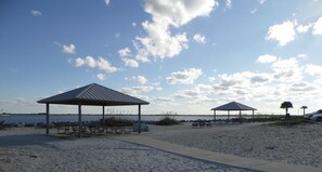 Ein Strand mit Picknickzelten und blauem Himmel.