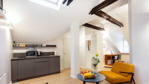 A modern apartment with a kitchen, dining area, and a living room with a sofa and a table. - Jolly apartments (Vilnius)