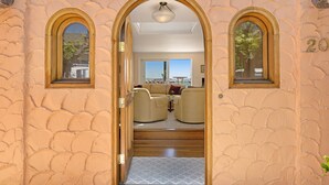 A doorway leading to a living area with two sofas, a small table, and a view of the outdoors. - BEACH FRONT LUXURY VENETIAN - 2 Jacuzzi Tubs - 2 Parking Passes - BBQ (Capitola)