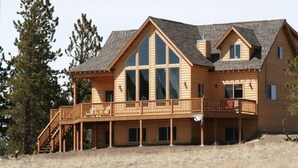 Un'ampia baita di legno con un balcone e diverse finestre.