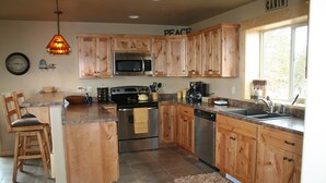 Una cucina con mobili in legno, un forno a microonde, un piano cottura e una macchina per il caffè.
