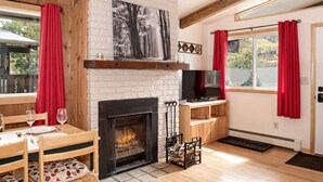 Un salon chaleureux avec une cheminée, des meubles en bois et un téléviseur.