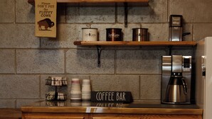 A kitchen with wooden cabinets, a coffee bar sign, and a coffee machine.