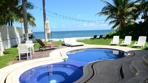 A swimming pool with lounge chairs and a view of the ocean. - Beautiful 4 bedroom Beach House on a Private & Peaceful Place in Cancun (Cancún)