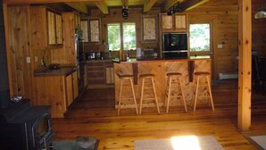 L’intérieur d’un chalet en bois rustique comprend une cuisine, un coin bar et un espace détente.