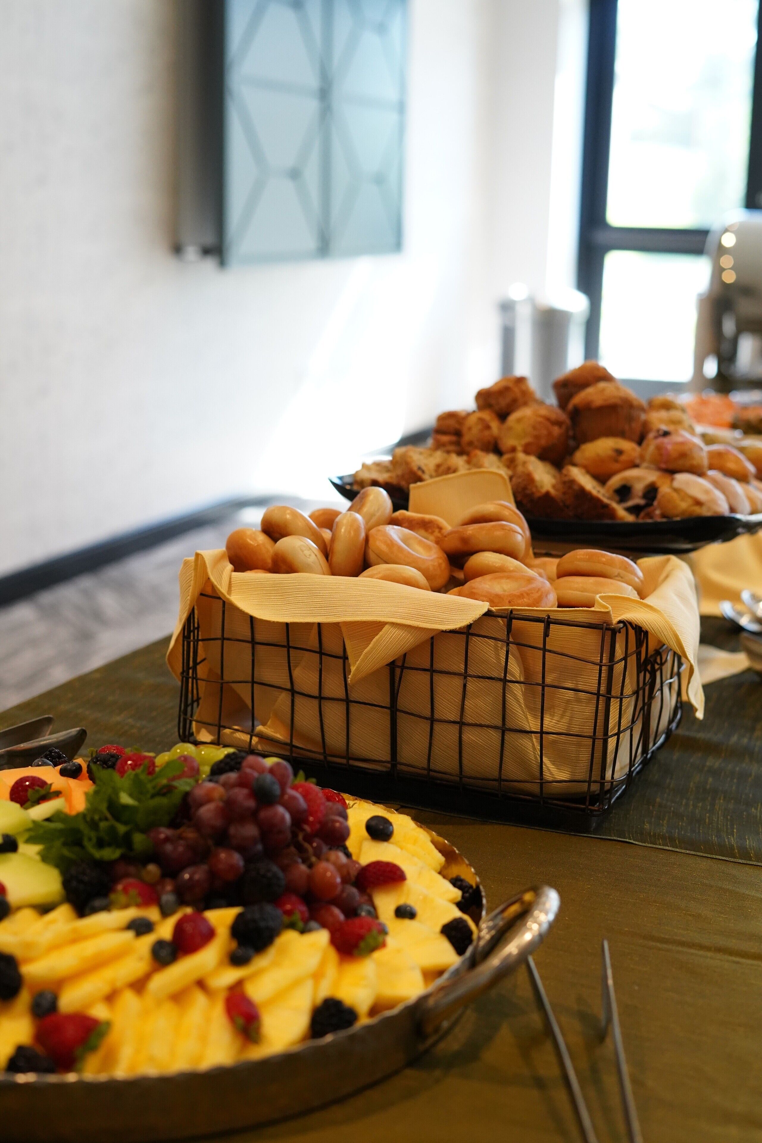A buffet table with various baked goods and a fruit platter.