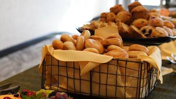 A buffet table with various baked goods and a fruit platter.
