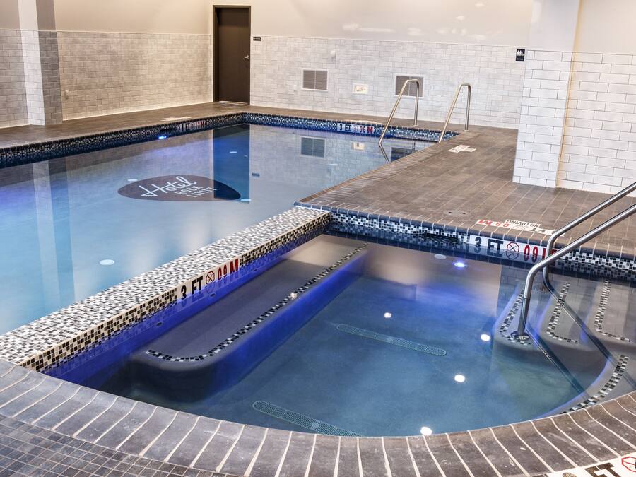 Una piscina con borde de azulejos, un puesto de socorrista y un cartel que indica una profundidad de 3 pies.