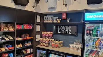 A hotel lobby with a snack bar, refrigerated display cases, and a 'Cold Drinks' sign.