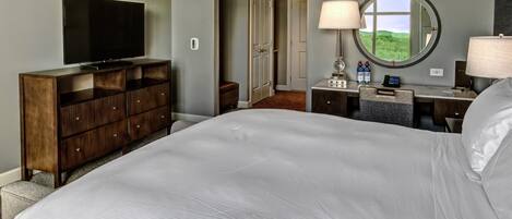 Habitación de hotel con una cama grande, televisión, escritorio con lámpara y vistas al exterior a través de una ventana.