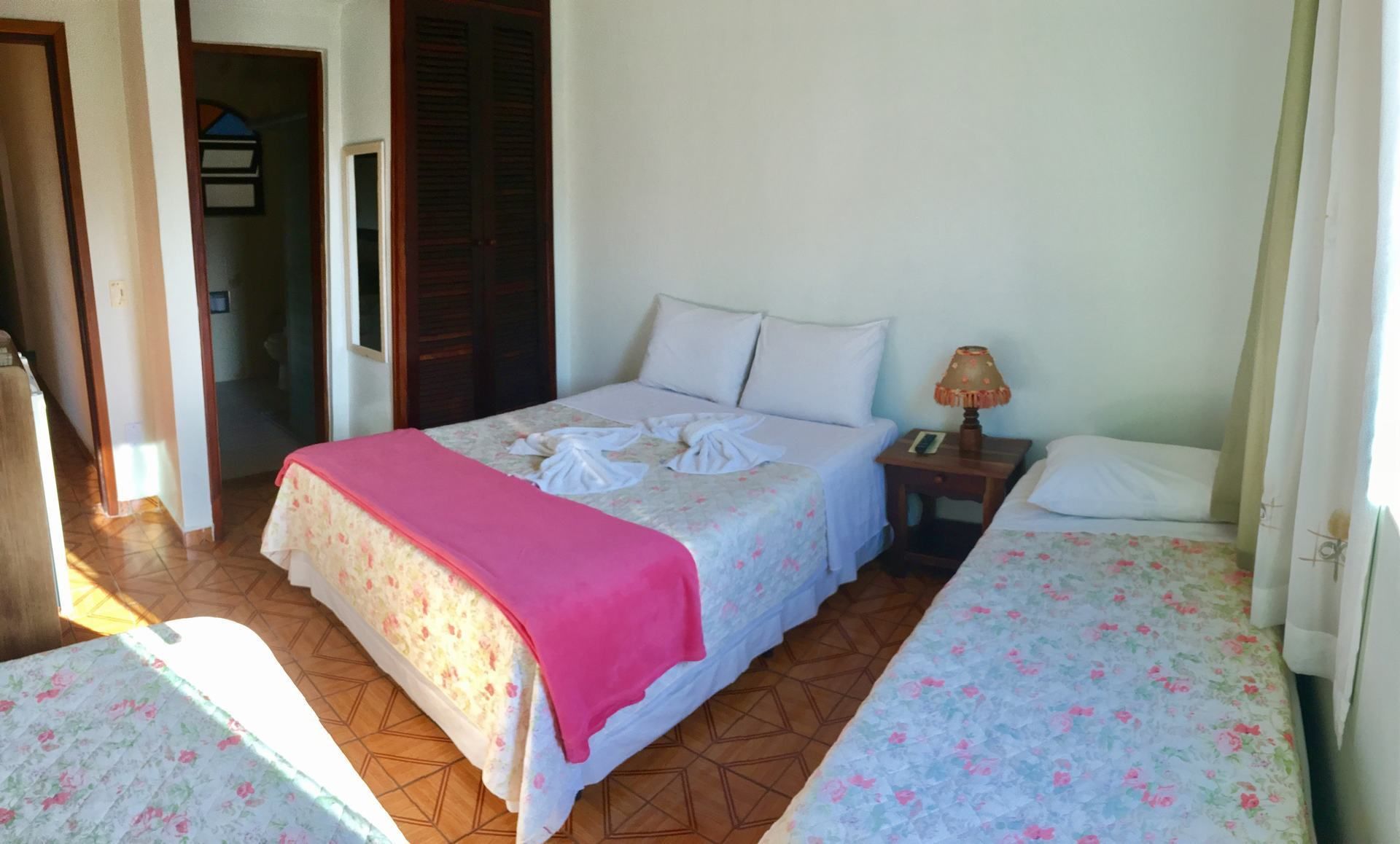 A bedroom with a bed, a bedside table, and a nightstand.