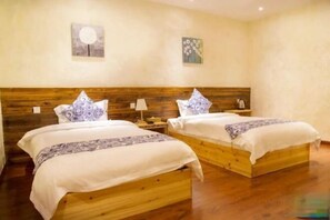 Una habitación de hotel con dos camas de madera, ropa de cama blanca y cabeceros de madera.