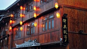 Un bâtiment traditionnel en bois, doté de nombreuses fenêtres et d’une enseigne.
