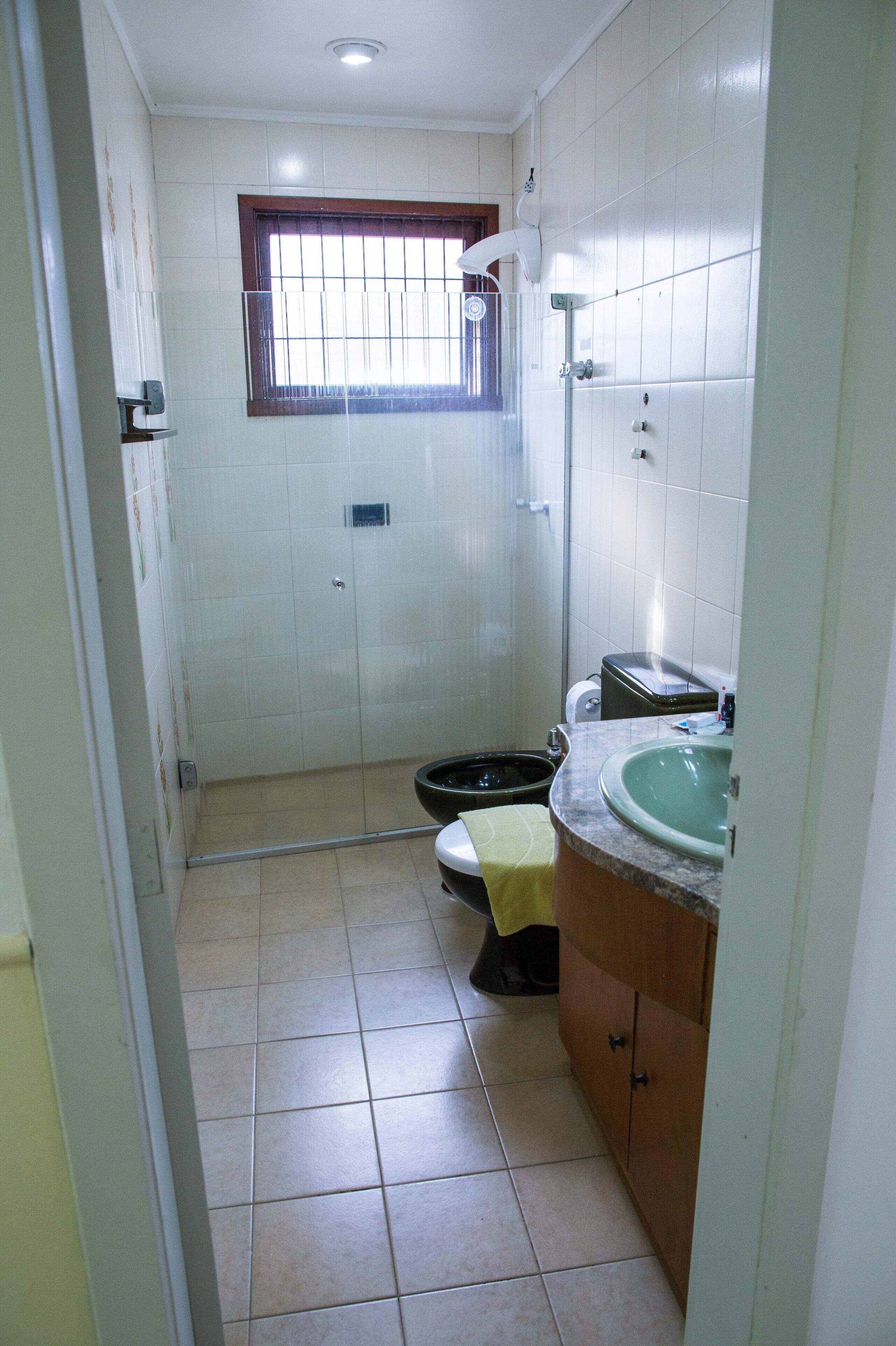 Een kleine badkamer met toilet, wastafel en douchecabine.