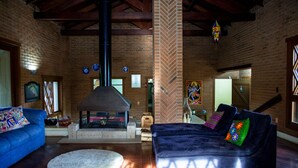 A cozy living room with a fireplace, blue sofa, and a large window. - OM B&B & Spa (Viamao)