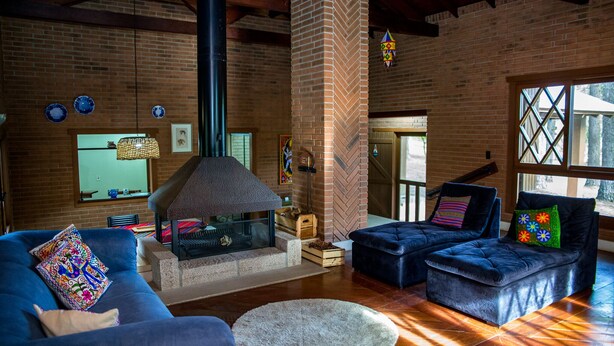 A cozy living room with a fireplace, blue sofas, and a large window. - OM B&B & Spa (Viamao)