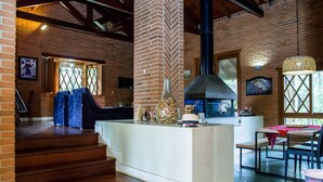 A rustic interior with a brick wall, wooden staircase, and a central island with a grill. - OM B&B & Spa (Viamao)