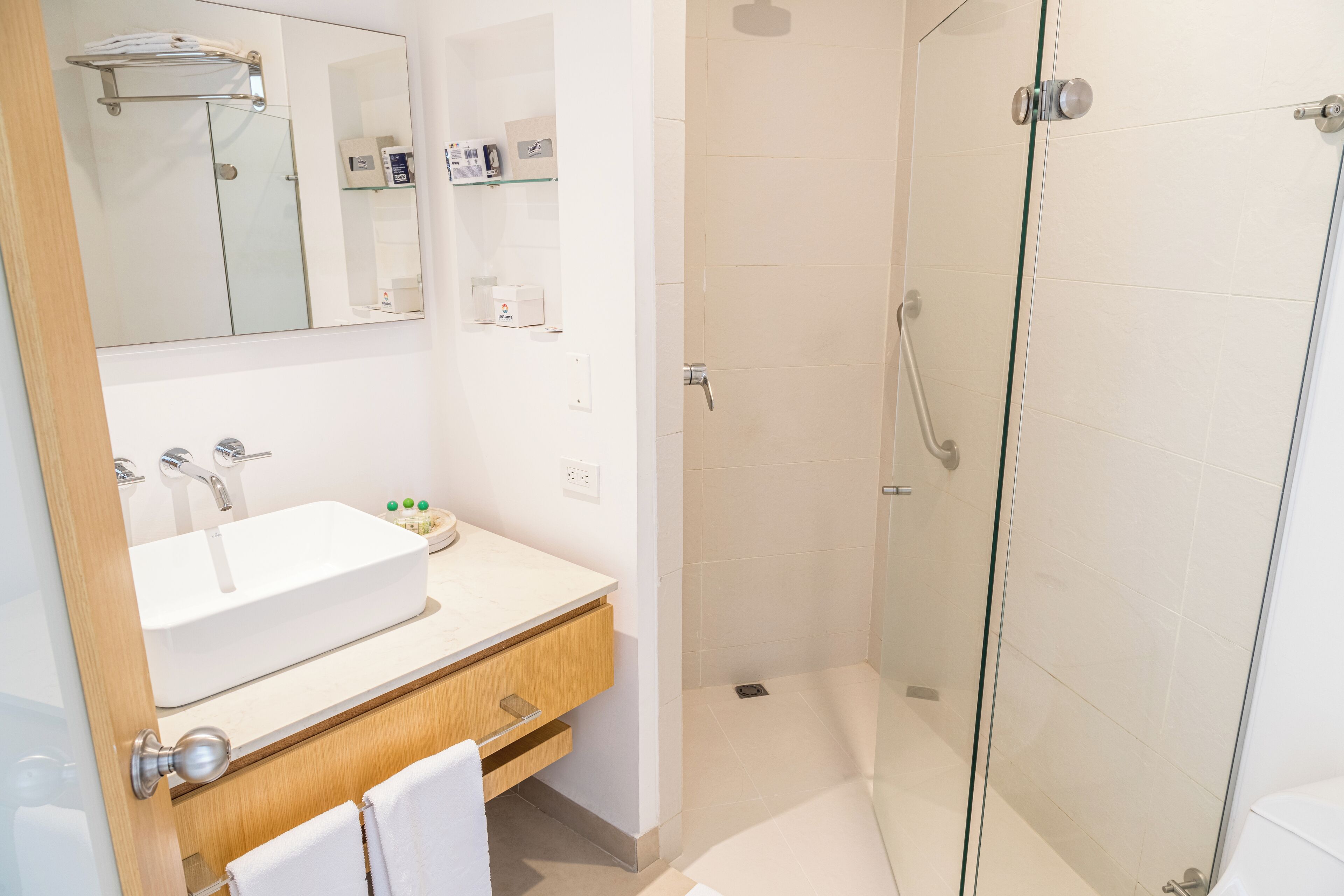 Une salle de bain moderne avec un grand lavabo, un miroir et une douche à parois de verre.