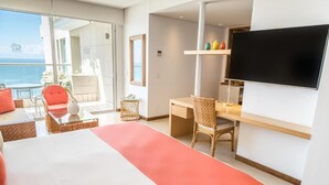 A modern hotel room with a large bed, a desk, a chair, a TV, and a balcony with a view of the ocean. - Hotel Irotama Reservado (Santa Marta)