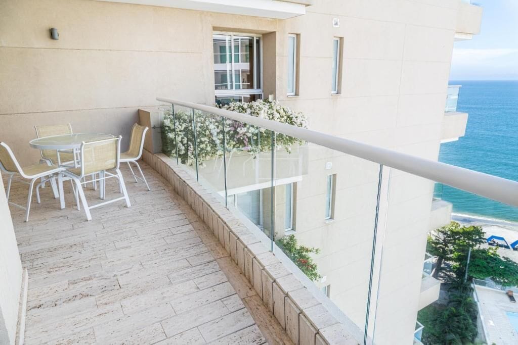 Un balcón con una mesa y sillas, con vista a una masa de agua.