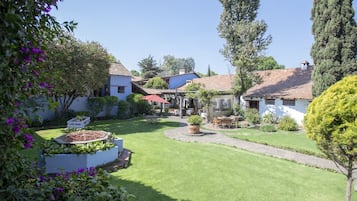 A well-maintained garden with a lawn, potted plants, and outdoor furniture.