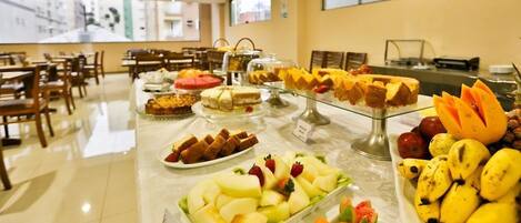 Buffet com diversas frutas e sobremesas.