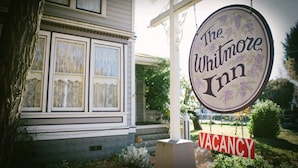 Un cartel para The Whitmore Inn con un letrero que dice 'VACANCY'.