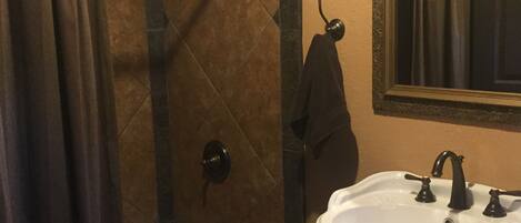 A bathroom with a bathtub, a sink, and a shower area.
